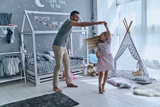 Haus-Vater-Tochter-Wohnen-Serie-4-1 Vater und Tochter tanzen im Kinderzimmer.